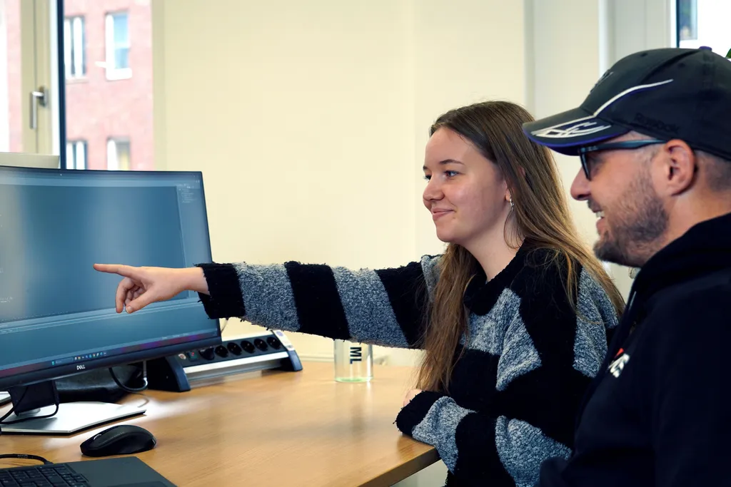 Peer-Programming-Session mit Entwickler, der etwas auf einem Bildschirm zeigt