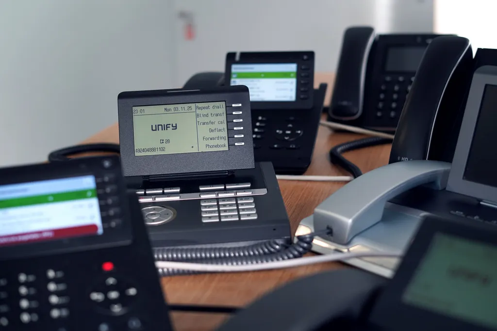 Desk phones arranged in office environment