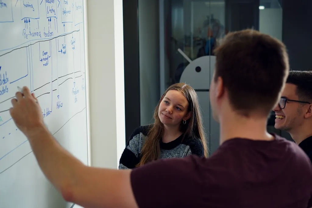 Entwickler diskutieren Softwarearchitektur vor einem Whiteboard