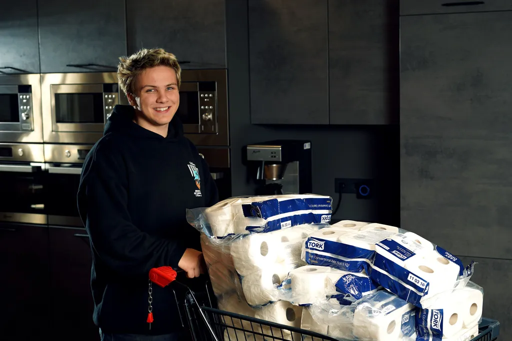 One of our trainees pushing a shopping cart filled with toilet paper