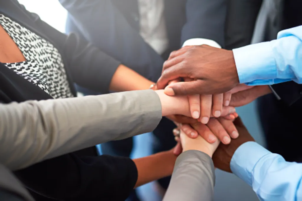 Hände unterschiedlicher Hautfarben, die aufeinander liegen